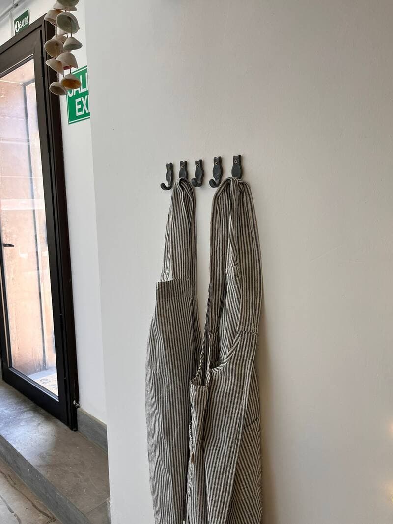 Delantales del taller colgados en percheros de gato